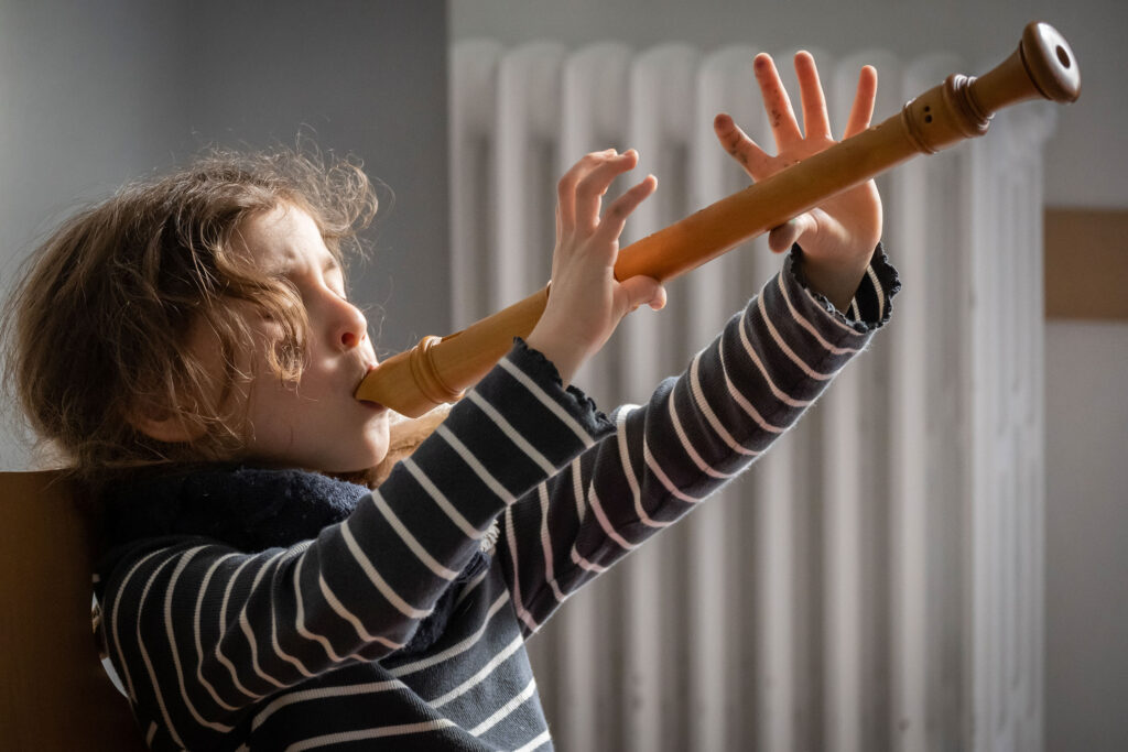Un jeune élève découvre la flûte à bec.